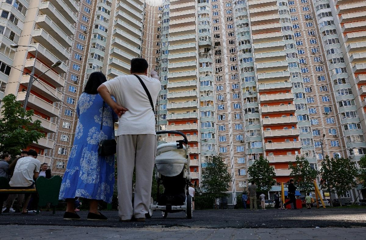 People stand in front of an apartment building damaged during a Ukrainian drone attack in the course of Russia-Ukraine conflict in Krasnogorsk, in the Moscow region, Russia May 17, 2026. REUTERS/Stringer