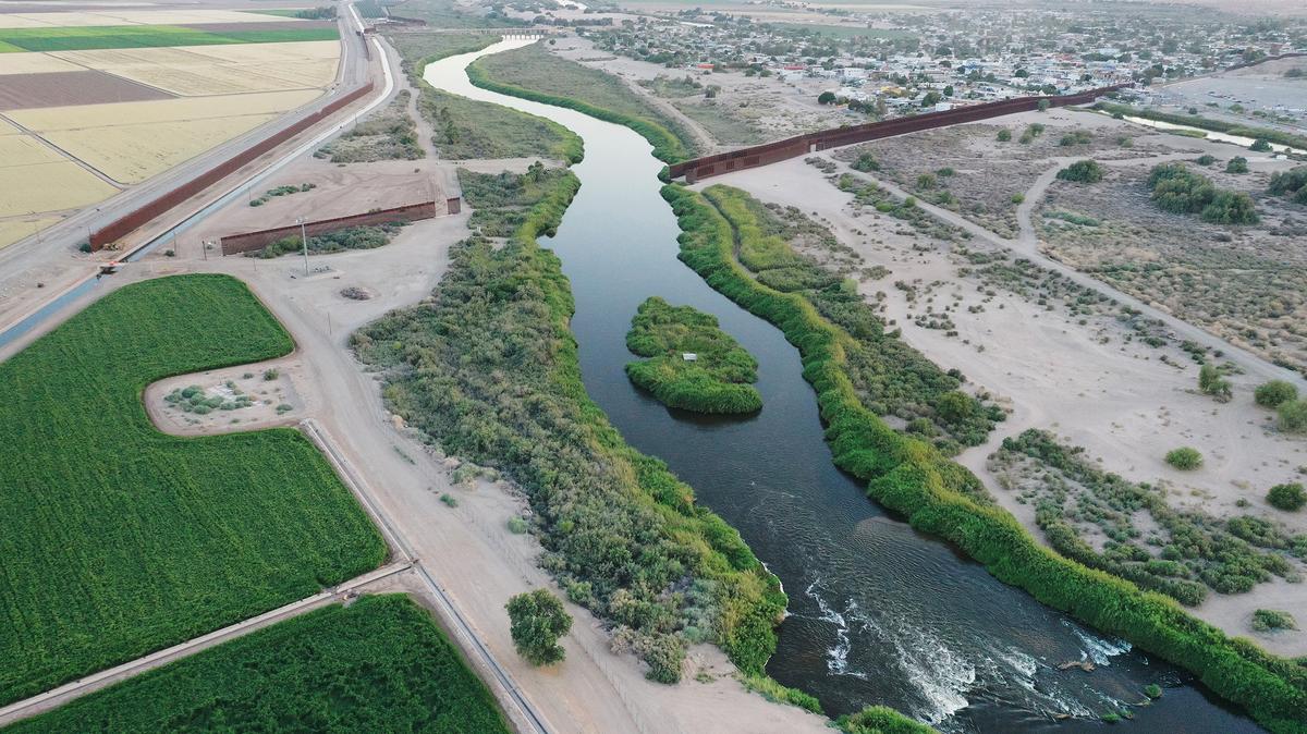 In an aerial view, the long-depleted Colorado River, currently swollen by winter snowmelt water, flows into Mexico (top right) past the border barrier on May 26, 2023, near Yuma, Arizona. States along the drought-stricken Colorado River, a source of drinking water for 40 million people, reached an agreement with the Biden administration earlier this week on water supply conservation. California, Arizona and Nevada, states which make up the Lower Basin of the river, have agreed to save 3 million acre-feet of water by 2026, in exchange for $1.2 billion in federal funds. (Mario Tama/Getty Images/TNS)