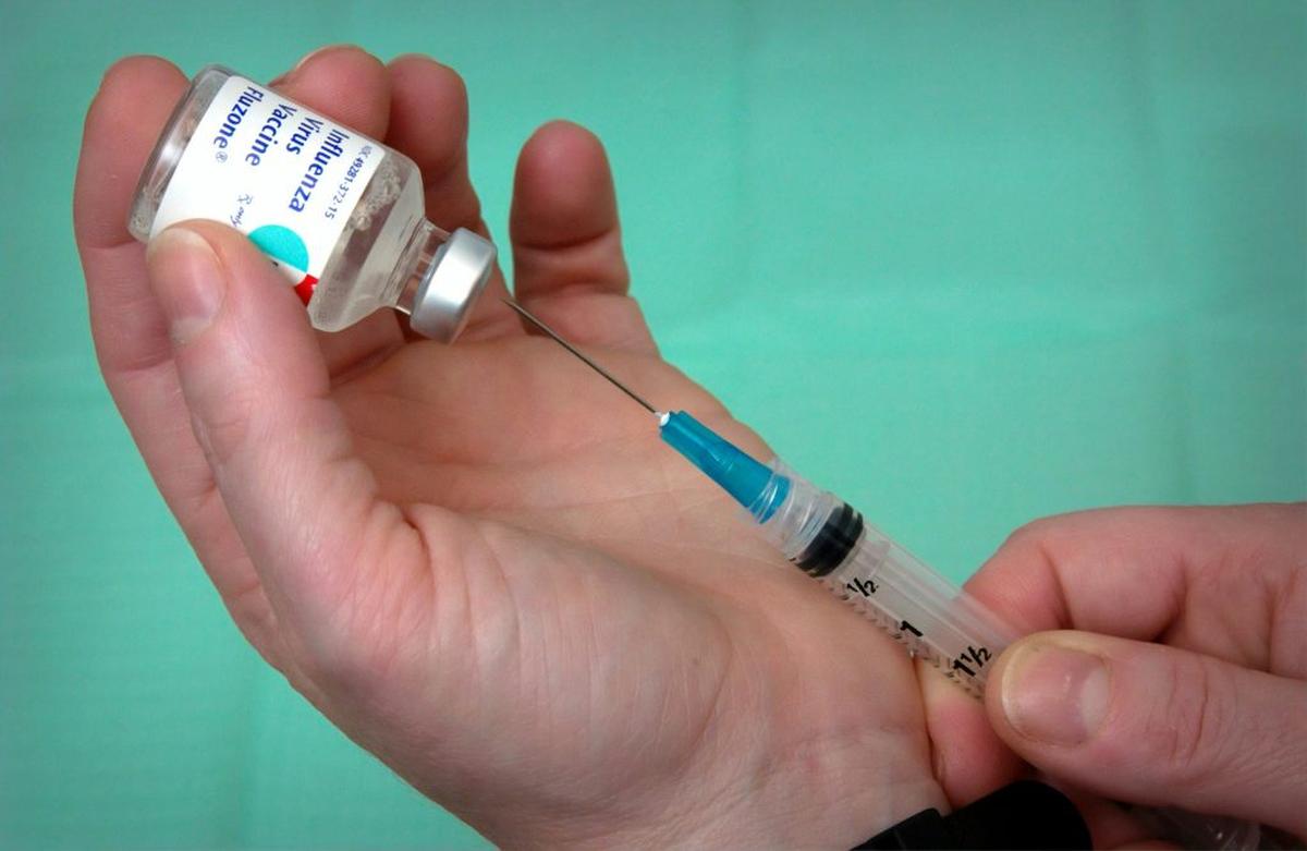 Someone fills a needle with a influenza vaccine. (Photo by CDC via Unsplash) 