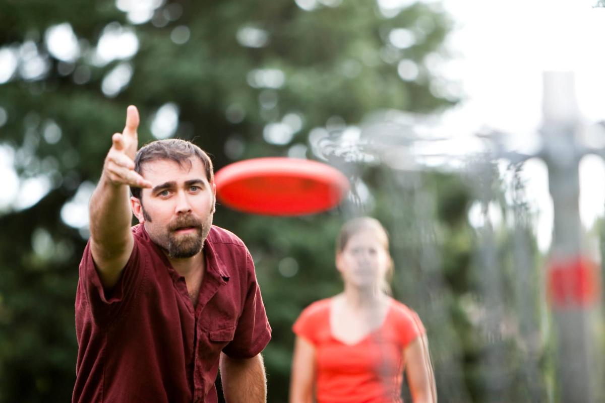  A man and woman play frisbee golf.