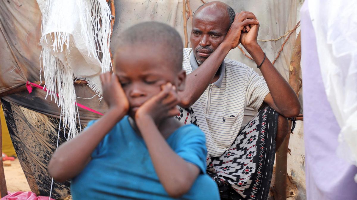 Internally displaced people sit outside their makeshift shelters during a visit by World Food Programme’s Assistant Executive Director for Programme Operations, Matthew Hollingworth (not in the photo), to assess the knock on effects from the escalation in the Middle East, alongside drought and sharp cuts in humanitarian funding that are worsening hunger, in Kahda district of Mogadishu, Somalia May 7, 2026. REUTERS/Feisal Omar
