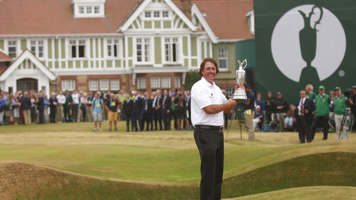 FILE - This is a Sunday July 21, 2013 file photo of Phil Mickelson of the United States holds up the Claret Jug trophy in front of the clubhouse after winning the British Open Golf Championship at Muirfield, Scotland. Muirfield voted Tuesday March 14, 2017 to admit female members for the first time in its 273-year history, paving the way for the Scottish golf club to again host the British Open.