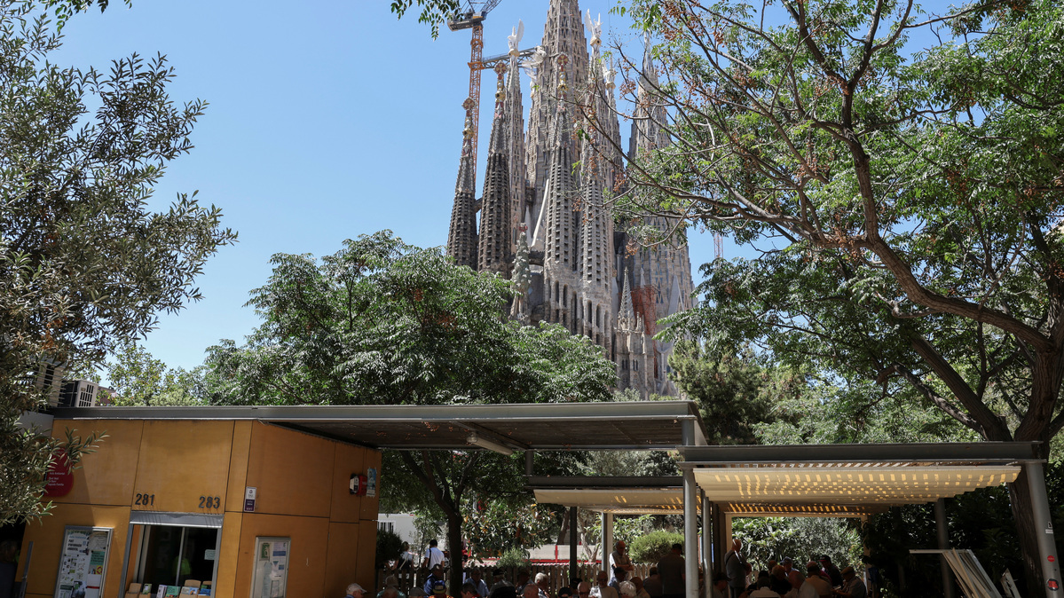 Neighbours play cards and dominoes in front of the Sagrada Familia basilica, designed by Catalan architect Antoni Gaudi, ahead of Pope Leo XIV's visit to Barcelona, ​​Spain, June 3, 2026. REUTERS/Nacho Doce