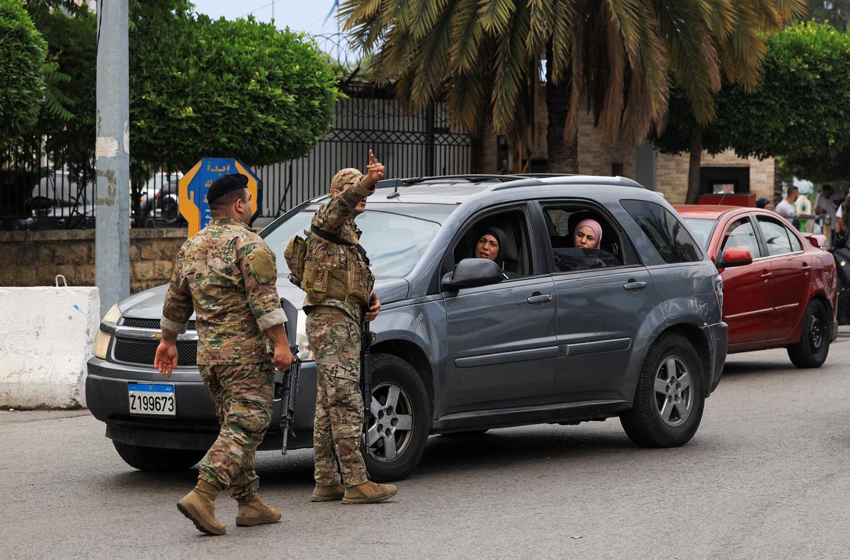 A member of the security personnel gestures gesture while standing on a road as people make their way while they flee the southern suburbs of Beirut, after Israeli Prime Minister Benjamin Netanyahu ordered the military to attack targets in the suburbs, Lebanon, June 1, 2026. REUTERS/Mohamed Azakir