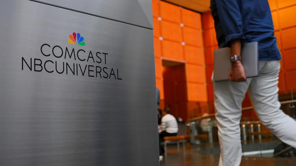 A person walks past a signage of Comcast and NBC Universal in the lobby of the corporate headquarters of Comcast, which announced plans to spin-off the bulk of its fading NBCUniversal cable TV networks, including MSNBC and CNBC, in Philadelphia, Pennsylvania, U.S. November 20, 2024. REUTERS/Bastiaan Slabbers