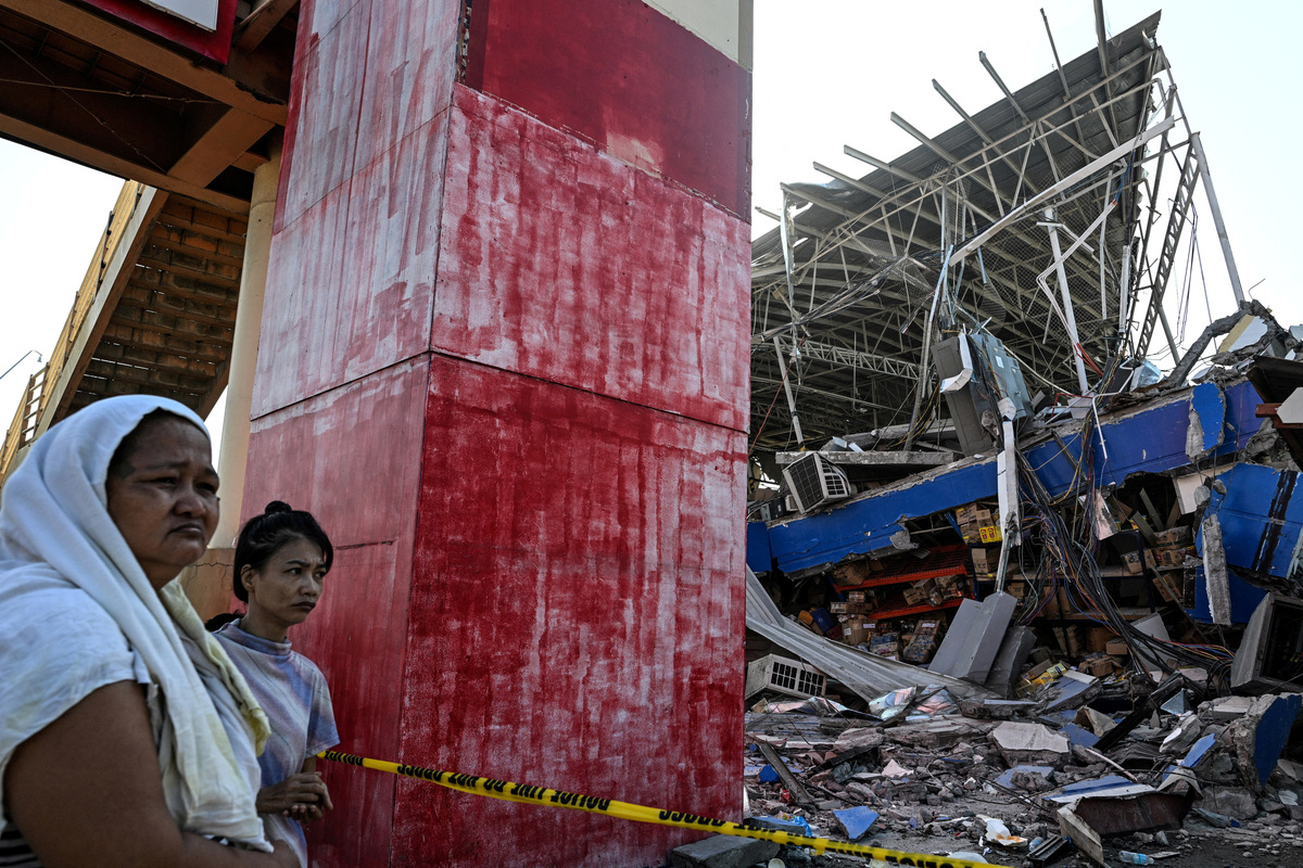 People look at a collapsed grocery store a day after the magnitude 7.8 earthquake, in Calumpang, General Santos, southern Philippines, June 9, 2026. REUTERS/Noel Celis
