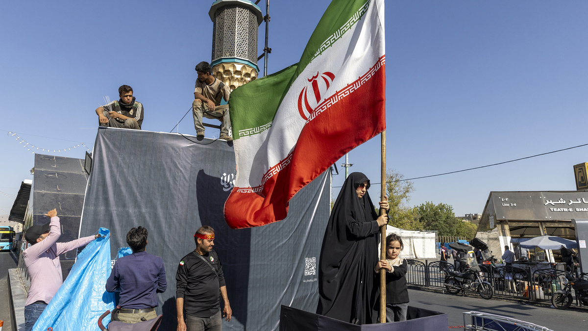 A woman is seen holding the Iranian Flag on June 15, 2026, in Tehran, Iran. According to reports, the U.S. and Iran have signed a preliminary agreement to end the war and open the Strait of Hormuz. (Majid Saeedi/Getty Images/TNS)