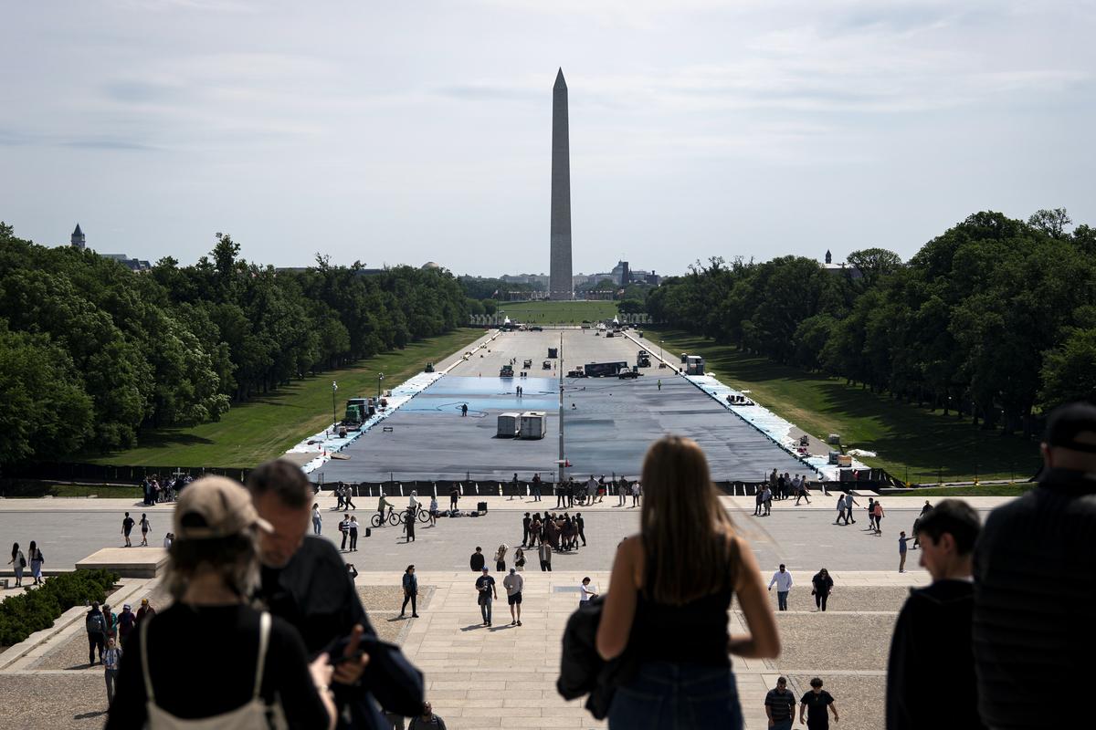 Visitors at the Lincoln Memorial in Washington as work continues on the memorial's reflecting pool, with the Washington Monument in the background, on Saturday, May 9, 2026. Atlantic Industrial Coatings was hired to repair leaking joints between the pool's concrete slabs, waterproof the pool's bottom and paint it a shade called "American flag blue." (Al Drago/The New York Times)