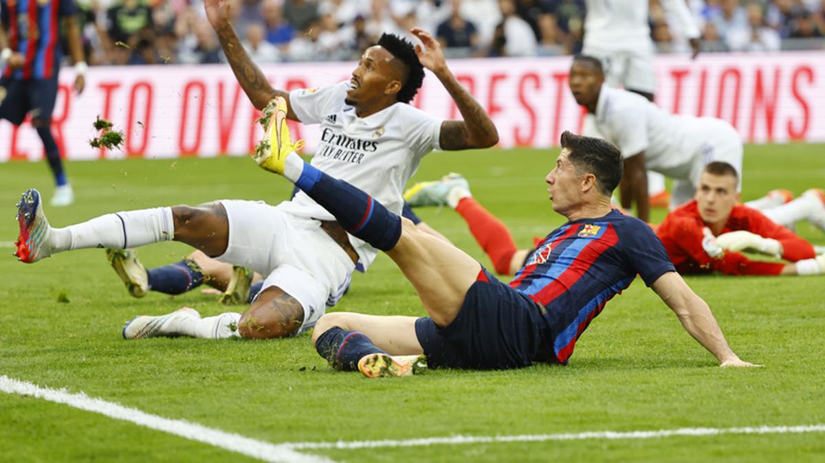 El delantero del Barcelona Robert Lewandowski (derecha) pugna por el balón con el defensa del Real Madrid Eder Militao, en el partido celebrado el 16 de octubre de 2022 en el estadio Santiago Bernabéu de Madrid.