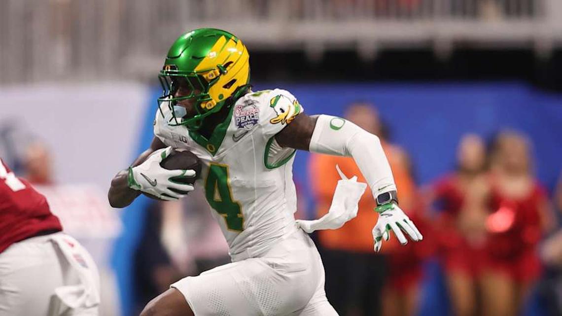  Jan 9, 2026; Atlanta, GA, USA; Oregon Ducks wide receiver Malik Benson (4) runs the ball against Indiana Hoosiers defensive back Louis Moore (7) during the first quarter of the 2025 Peach Bowl and semifinal game of the College Football Playoff at Mercedes-Benz Stadium. Mandatory Credit: Brett Davis-Imagn Images | Brett Davis-Imagn Images 