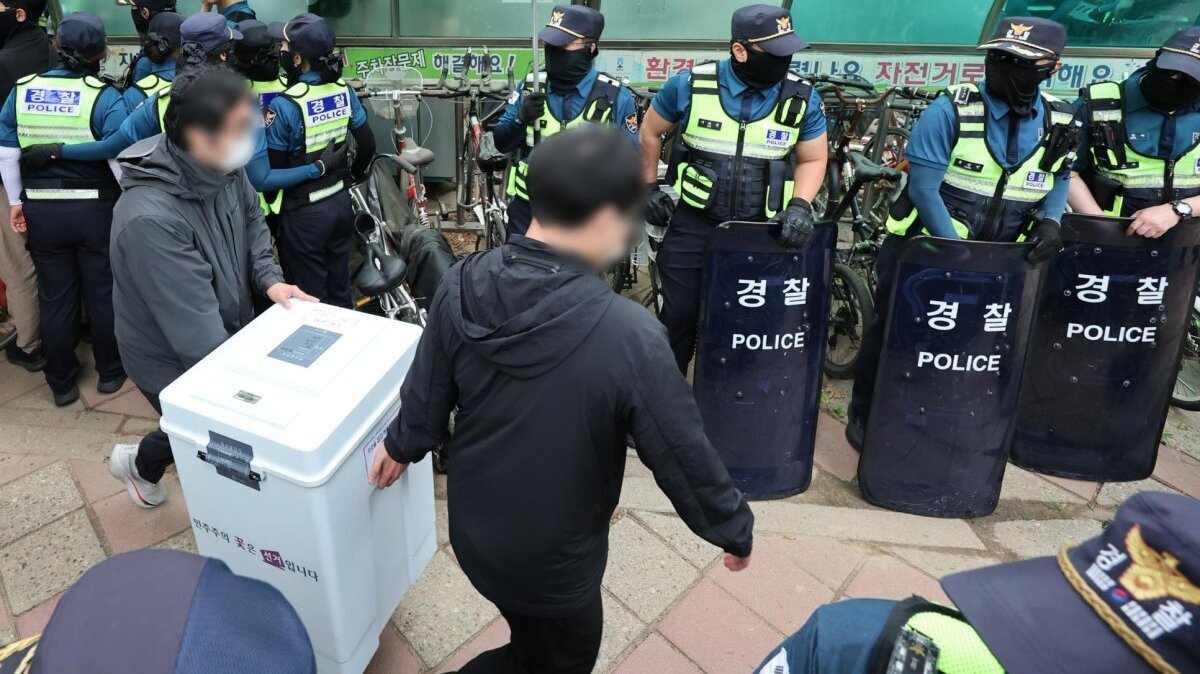 Officials remove ballot boxes from a polling station in southern Seoul on Friday after breaking up protesters who had gathered in protest of a shortage of ballots during the June 3 local elections. Photo by Yonhap