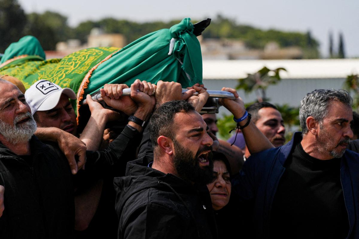 Mourners carry the body of one of the four people killed in an Israeli strike during the funeral, in Ansariyeh, Lebanon, May 8, 2026. REUTERS/Stringer