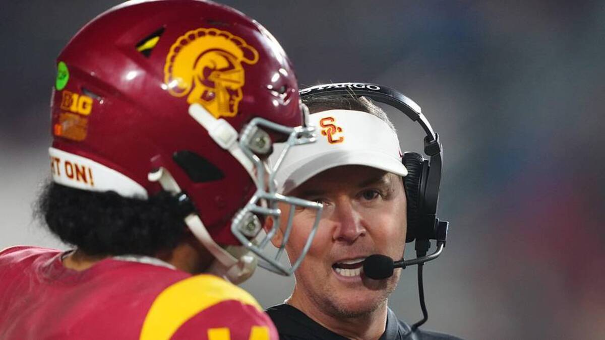  Nov 29, 2025; Los Angeles, California, USA; Southern California Trojans head coach Lincoln Riley (right) talks with quarterback Jayden Maiava (14) in the second half against the UCLA Bruins at United Airlines Field at Los Angeles Memorial Coliseum. Mandatory Credit: Kirby Lee-Imagn Images | Kirby Lee-Imagn Images 