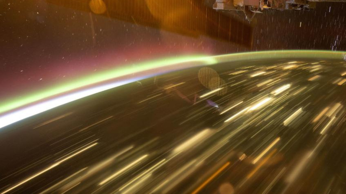 NASA astronaut captures auroras streaking over city lights from ISS 