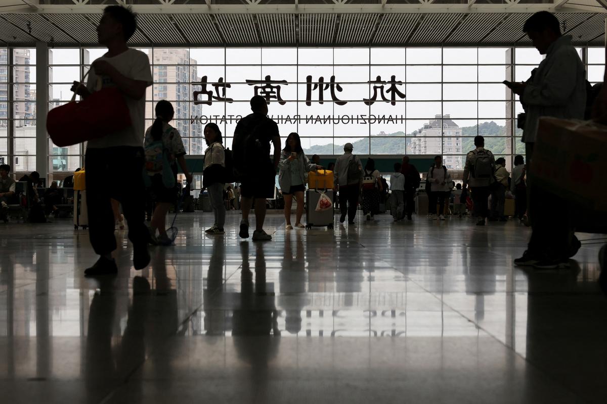People stand in the concourse of Hangzhou South Railway Station while waiting for their trains during the five-day Labour Day holiday in Hangzhou, China May 4, 2025. REUTERS/Go Nakamura