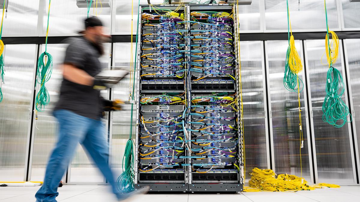 In this handout provided by Amazon, an Amazon Web Services technician passes an AWS UltraServer in Austin, Texas, on Oct. 2, 2025. (Noah Berger/Getty Images via Amazon Web Services/TNS)