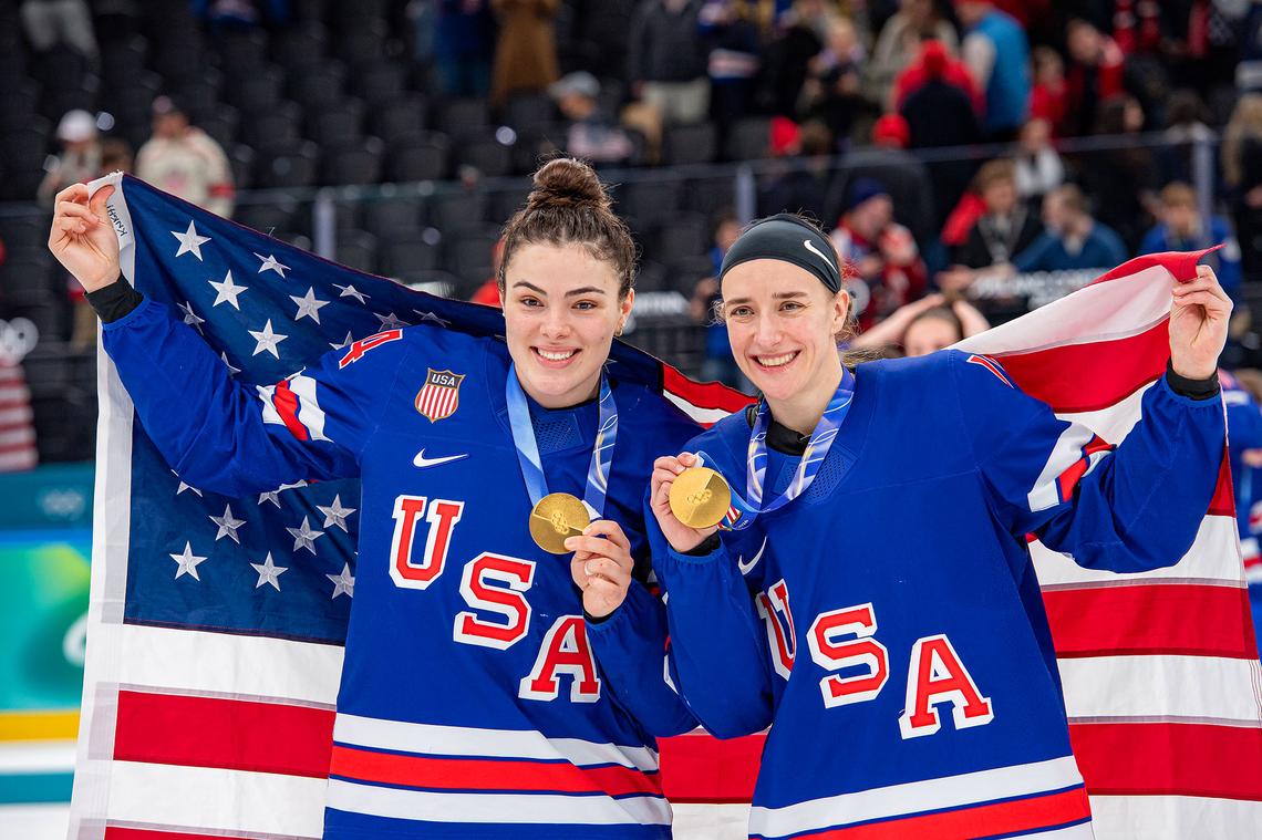 Joy Dunne #24 of United States, Megan Keller #5 of United States pose for a photo with their gold medal during the Women's Gold Medal match between United States and Canada on day thirteen of the Milano Cortina 2026 Winter Olympic games at Milano Santagiulia Ice Hockey Arena on February 19, 2026 in Milan, Italy.
