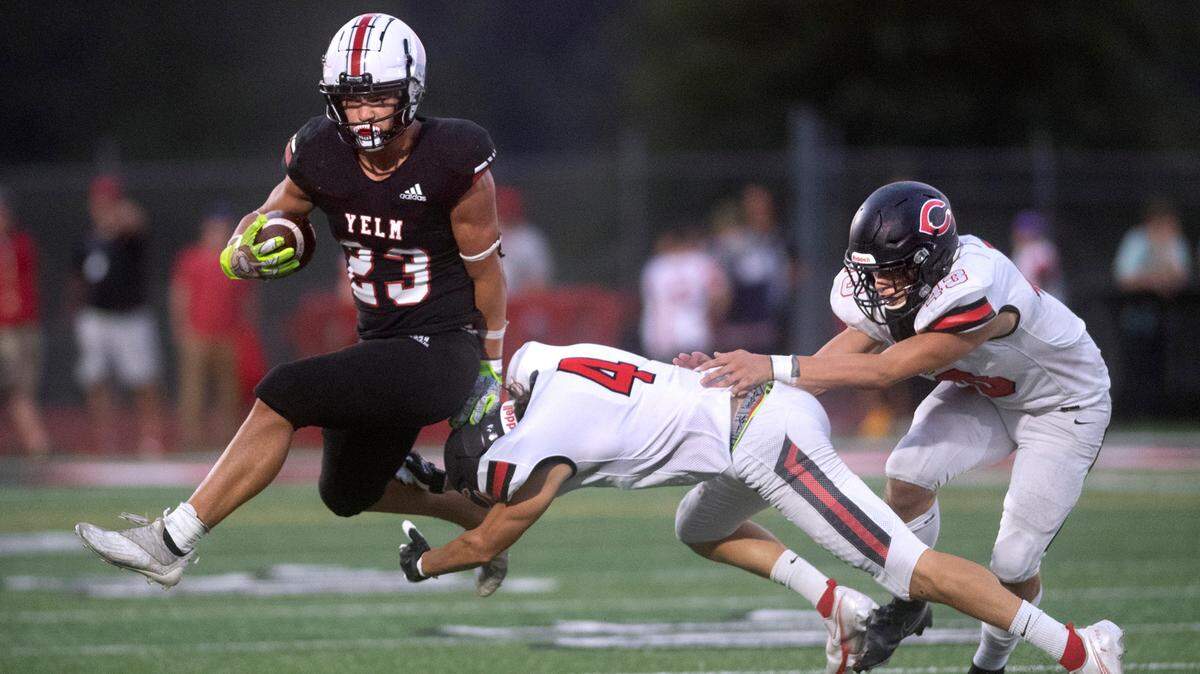 Yelm running back Brayden Platt leaps to elude Camas defensive back Jared Williams (4) and linebacker Nikko Speer during Friday night’s season-opening football game at Yelm High School in Yelm, Washington on Friday, Sept. 2, 2022.