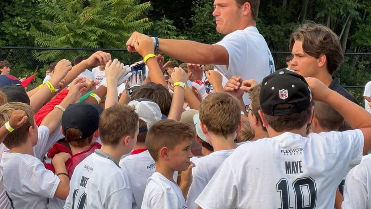  New England Patriots quarterback Drake Maye breaks down the huddle with a group of campers. | Ethan Hurwitz / Patriots On SI 