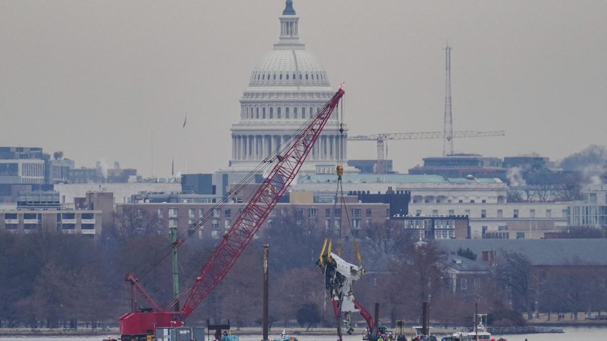 A crane retrieves part of the wreckage from the Potomac River, in the aftermath of the collision of American Eagle flight 5342 and a Black Hawk helicopter that crashed into the river, with the Capitol dome in the background, as seen from Virginia, U.S., February 3, 2025.REUTERS/Nathan Howard/File Photo