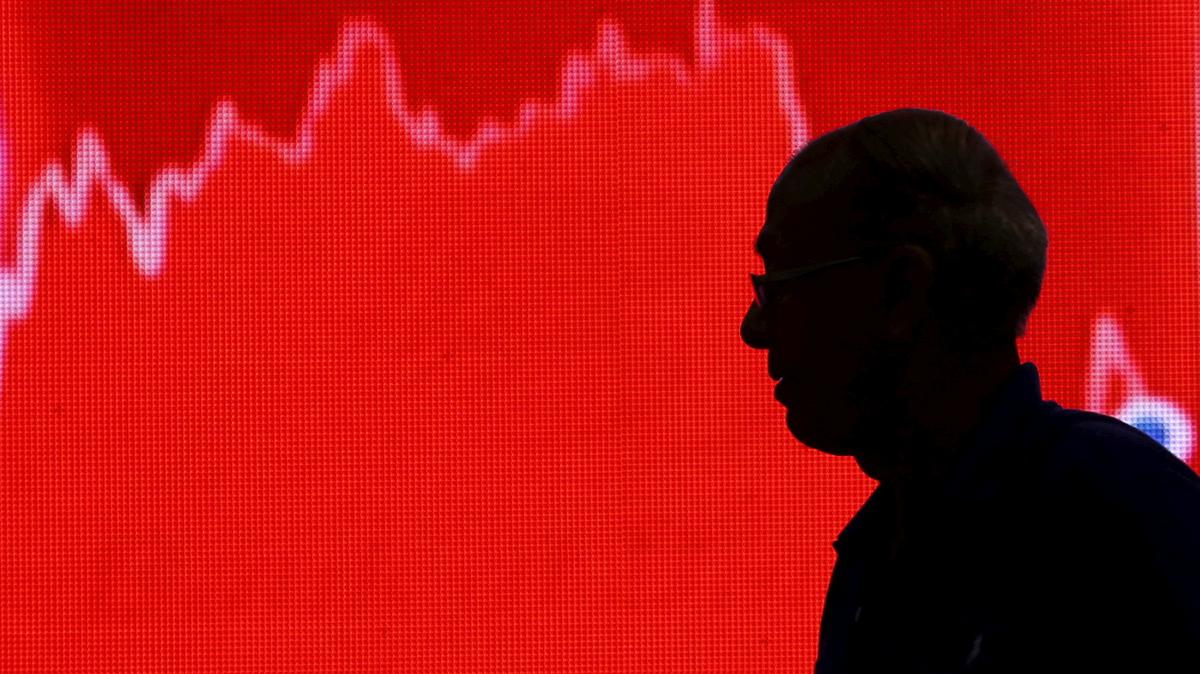 FILE PHOTO: A man looks at a screen displaying news of markets update inside the Bombay Stock Exchange (BSE) building in Mumbai, India, February 11, 2016. REUTERS/Danish Siddiqui/File Photo
