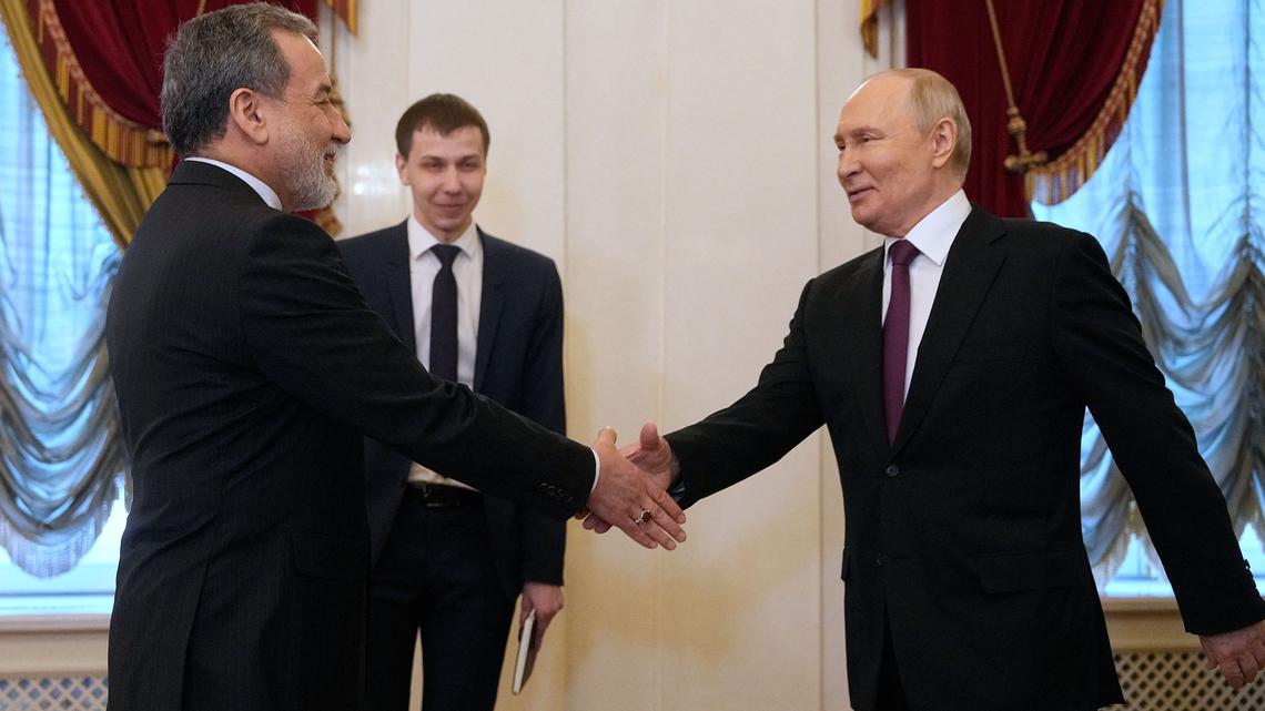 Russian President Vladimir Putin shakes hands with Iranian Foreign Minister Abbas Araghchi during their meeting at the Boris Yeltsin Presidential Library in Saint Petersburg on April 27, 2026. (Dmitry Lovetsky/Pool/AFP/Getty Images/TNS)