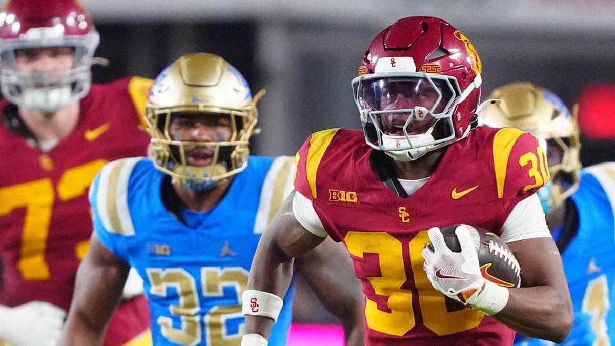  Nov 29, 2025; Los Angeles, California, USA; Southern California Trojans running back King Miller (30) carries the ball against UCLA Bruins linebacker Isaiah Chisom (32) in the first half at United Airlines Field at Los Angeles Memorial Coliseum. Mandatory Credit: Kirby Lee-Imagn Images | Kirby Lee-Imagn Images 