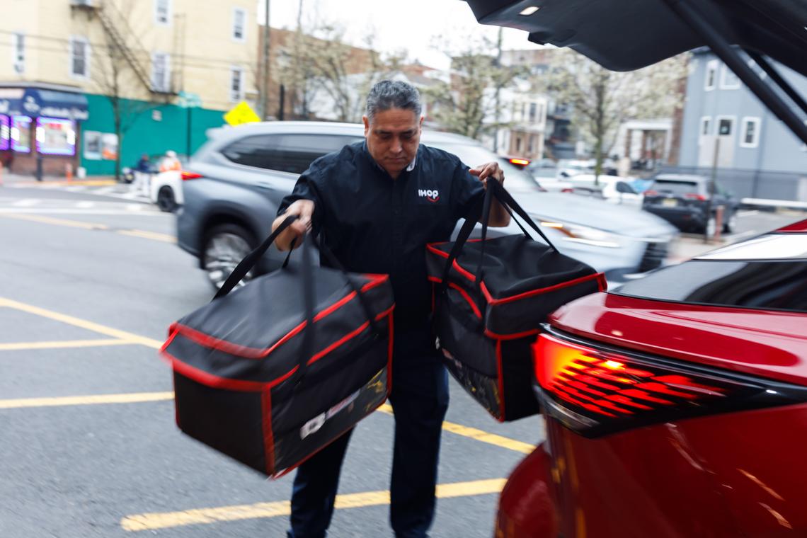 An IHOP employee arrives at Union City Firehouse with a catering order from the restaurant, in Union City, N.J., April 2, 2026. Restaurants like IHOP, Cracker Barrel and Red Lobster have found a new revenue source as return-to-office hits full force. (Brian Fraser/The New York Times)