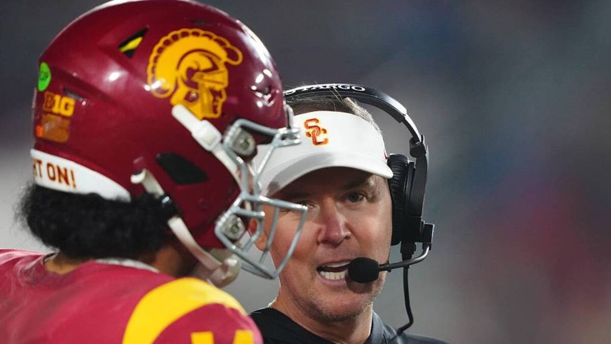  Nov 29, 2025; Los Angeles, California, USA; Southern California Trojans head coach Lincoln Riley (right) talks with quarterback Jayden Maiava (14) in the second half against the UCLA Bruins at United Airlines Field at Los Angeles Memorial Coliseum. Mandatory Credit: Kirby Lee-Imagn Images | Kirby Lee-Imagn Images 