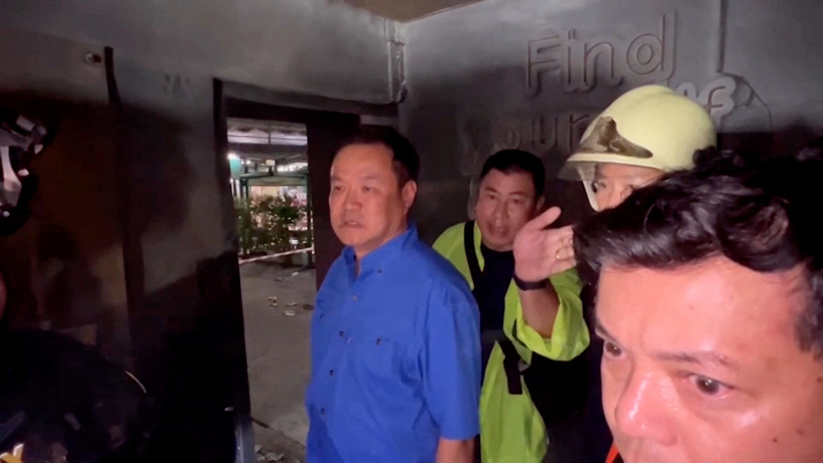 Thailand's Prime Minister Anutin Charnvirakul listens to an official as he visits the site of a deadly pub fire in Bangkok, Thailand, July 13, 2026, in this still image taken from handout video.    Government Spokesperson Bureau/Handout via REUTERS