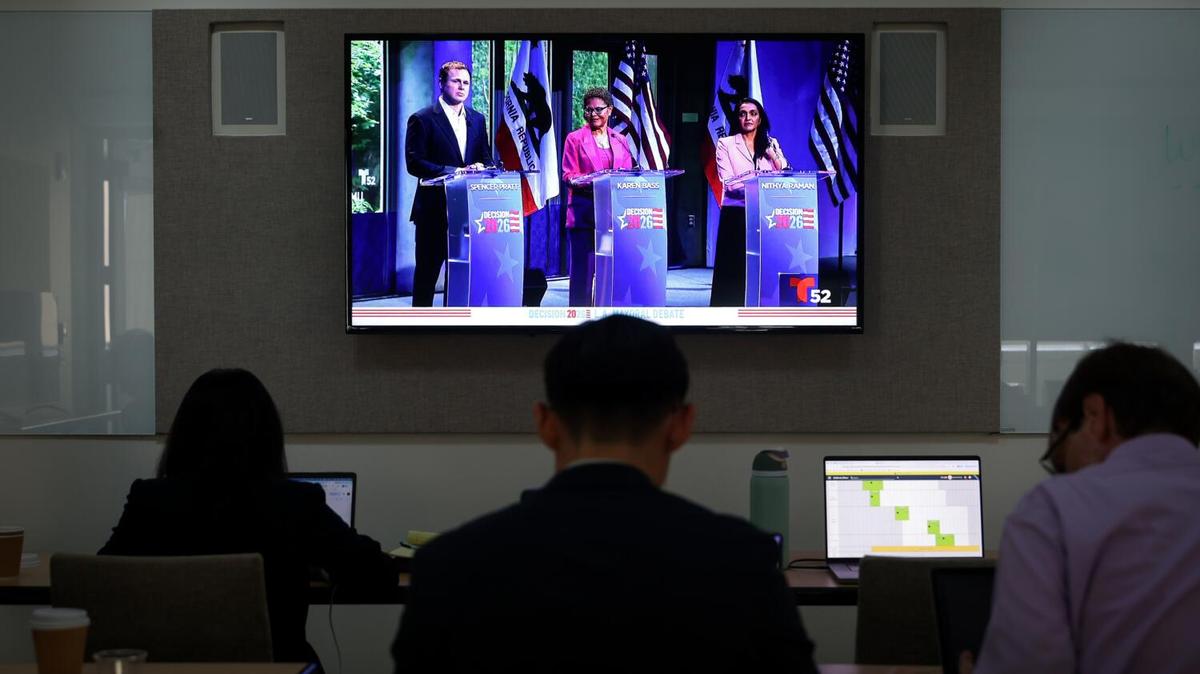 Spencer Pratt, from left, Karen Bass and Nithya Raman are shown on a television while journalists work as they take part in the Los Angeles mayoral debate at Skirball Cultural Center on May 6, 2026 in Los Angeles. (Jason Armond/Los Angeles Times/TNS)
