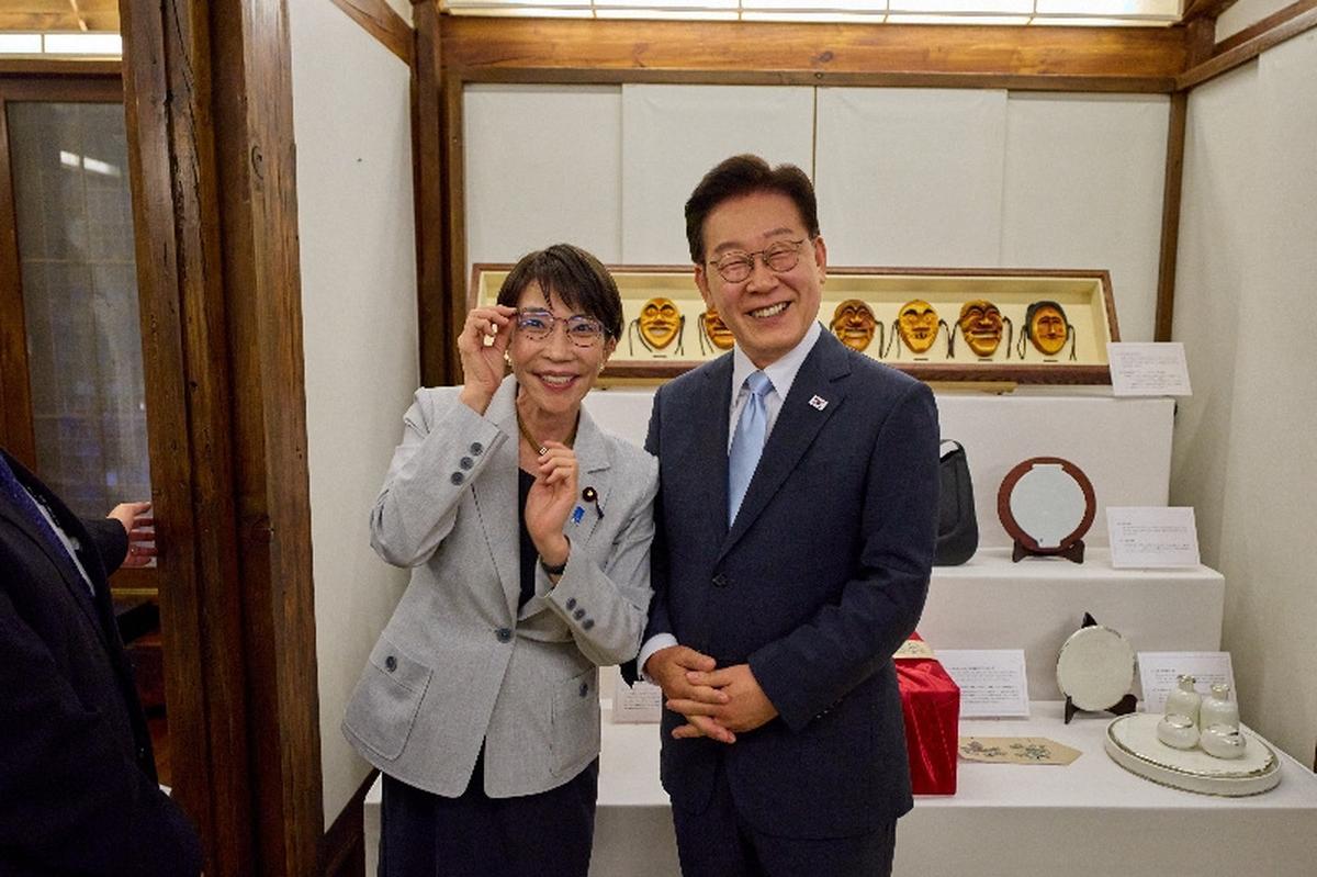Japanese Prime Minister Sanae Takaichi poses for photographs with glasses received from South Korean President Lee Jae Myung, in Andong, South Korea, May 19, 2026.   The Presidential Blue House/Yonhap via REUTERS