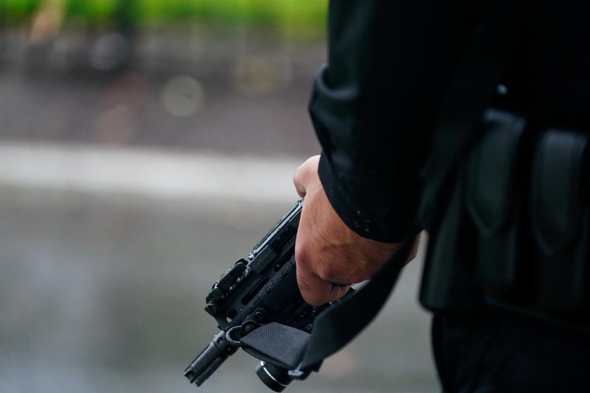 A U.S. Secret Service agent stands guard holding his weapon after alleged gunshots were heard nearby, at the White House in Washington, D.C., U.S., May 23, 2026. REUTERS/Nathan Howard