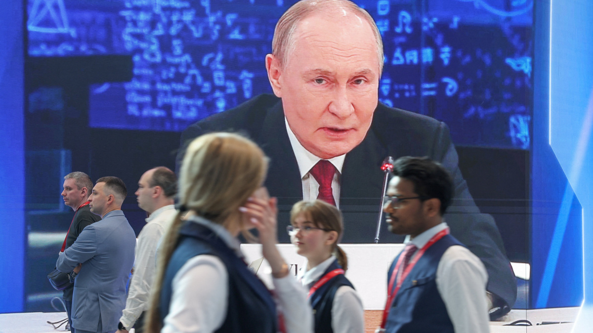 Participants walk past a screen showing Russia's President Vladimir Putin at the venue of the St. Petersburg International Economic Forum (SPIEF)  in Saint Petersburg, Russia June 3, 2026. REUTERS/Anastasia Barashkova