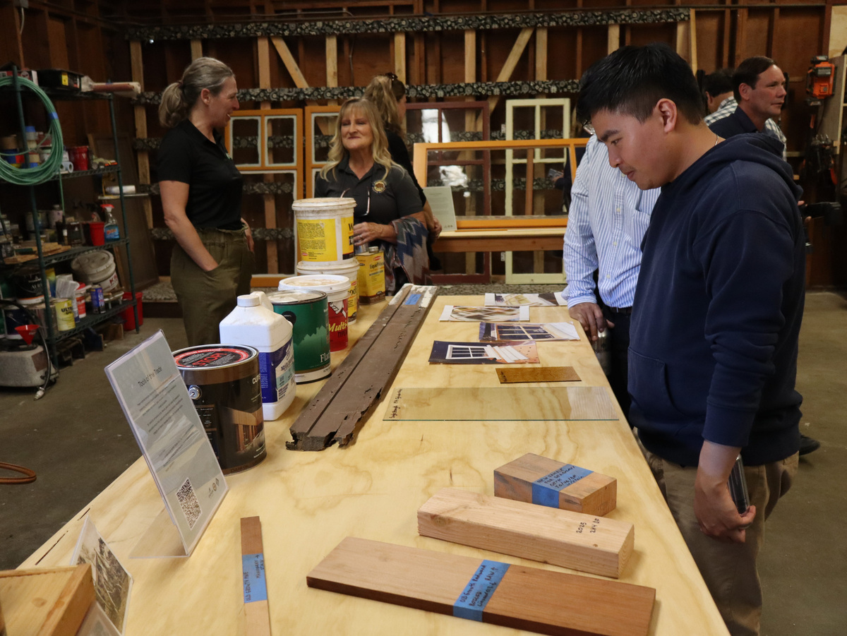 Vistors to the new historic preservation center on July 15, 2026, examine the difference between modern and historic or reclaimed building materials that will be used for historic preservation work at Asilomar Hotel and Conference Grounds in Pacific Grove, Calif.