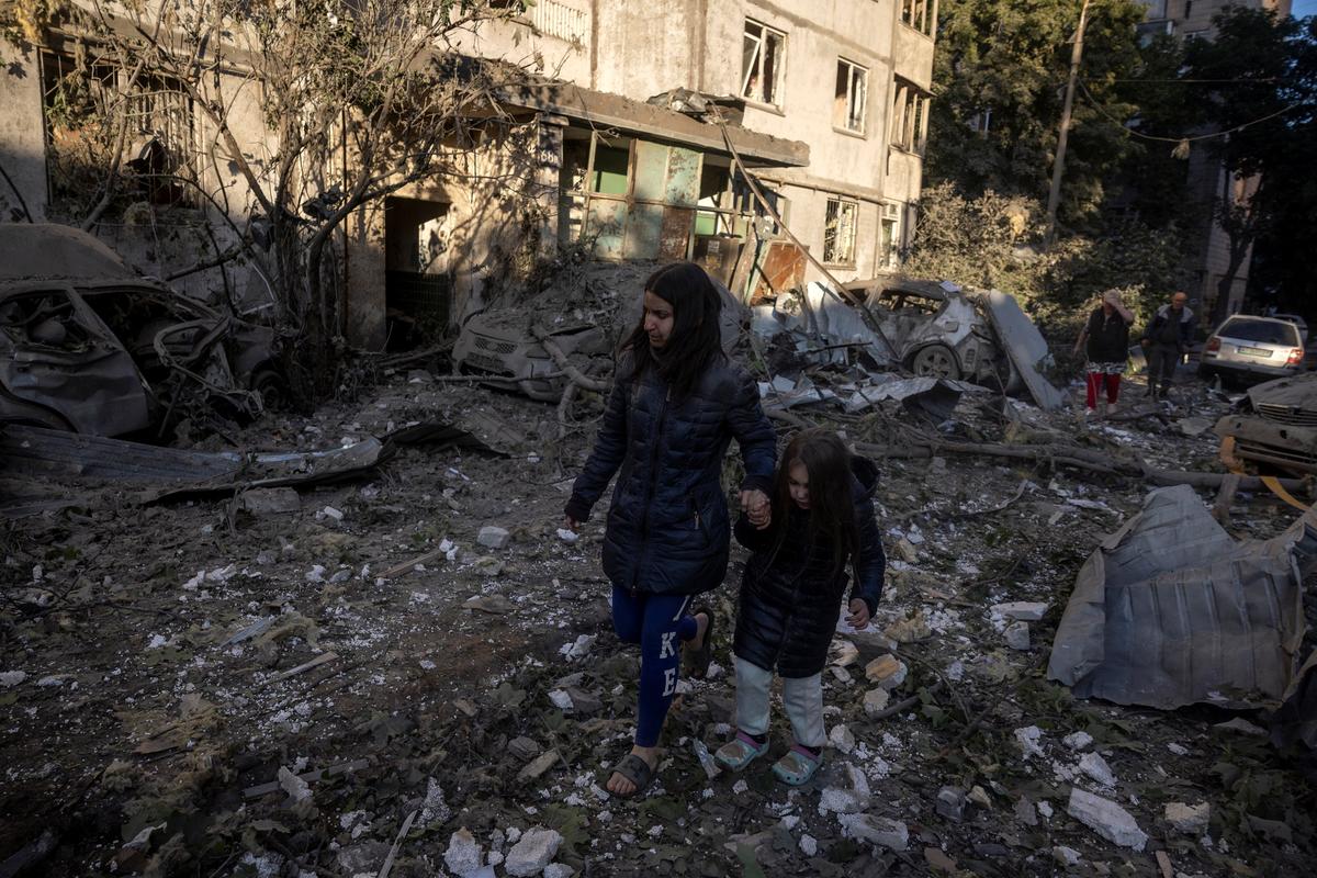 Resident Olha Mudra and her daughter Natalia, 6, walk through debris outside their apartment block after a nearby building got struck during overnight Russian missile and drone attacks, amid Russia's attack on Ukraine, in Kyiv, Ukraine, June 2, 2026. REUTERS/Thomas Peter
