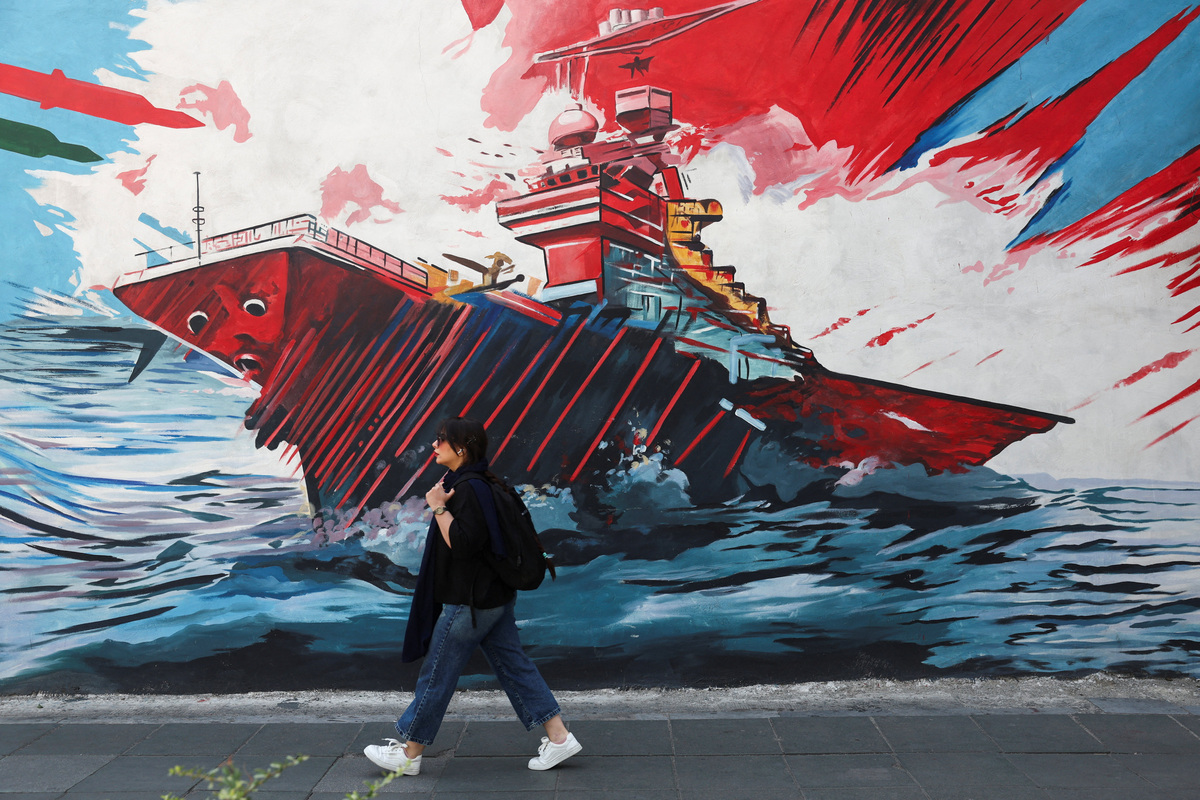 An Iranian woman walks next to an anti-U.S. mural on a street in Tehran, Iran, June 10, 2026. Majid Asgaripour/WANA (West Asia News Agency) via REUTERS