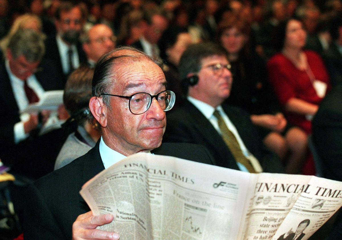 FILE PHOTO: U.S. Federal Reserve chairman Alan Greenspan glances up as he reads a business newspaper during the official opening ceremony of the World Bank/International Monetary Fund annual meeting in Hong Kong September 23.  Pool via REUTERS/File Photo