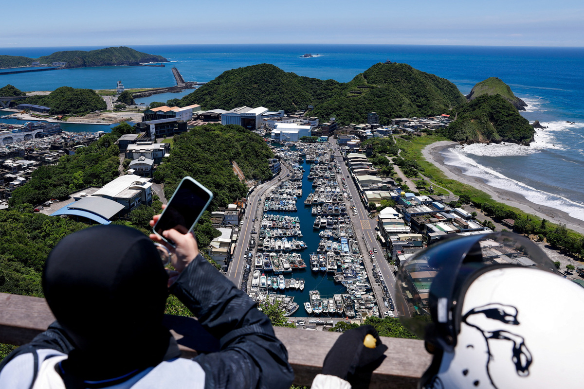 People take photos of of Suao Port, where fishing boats are sheltered as Typhoon Bavi approaches Taiwan, in Yilan, Taiwan, July 9, 2026. REUTERS/Ann Wang