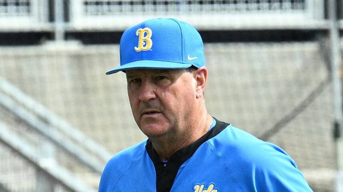  Jun 17, 2025; Omaha, Neb, USA; UCLA Bruins head coach John Savage (22) walks to the dugout before the restart of the game against the LSU Tigers at Charles Schwab Field. Mandatory Credit: Steven Branscombe-Imagn Images | Steven Branscombe-Imagn Images 
