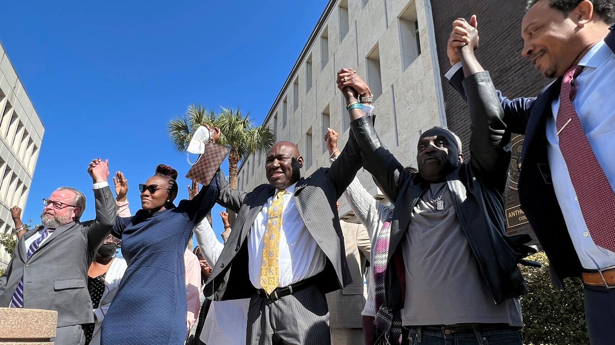 The family and attorneys of the Ahmaud Aubery raise their arms in victory after all three men were found guilty of hates crimes at the federal courthouse in Brunswick, Ga., on Tuesday.