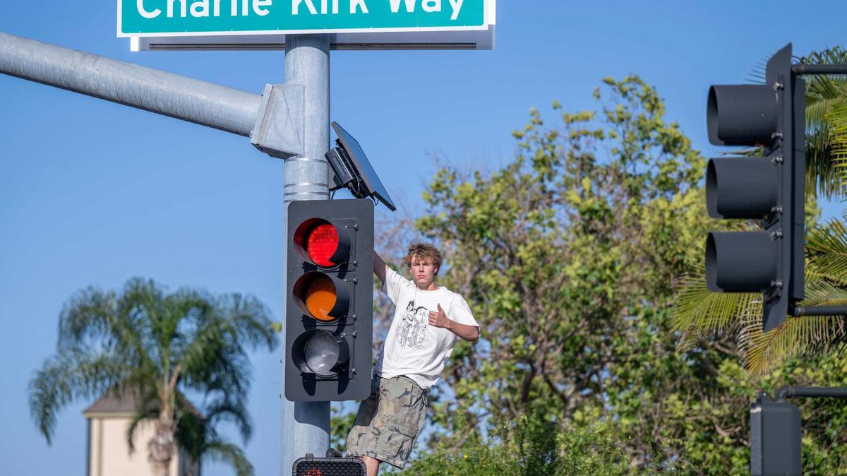 Gunner Shepardson of Seal Beach climbs a traffic light pole at the corner of Westminster Blvd. and the newly renamed "Charlie Kirk Way" to pose for a photo with the new controversial sign, renamed by the Westminster City Councilmembers, on Saturday, May 2, 2026. (Jeff Antenore/Orange County Register/SCNG/TNS)