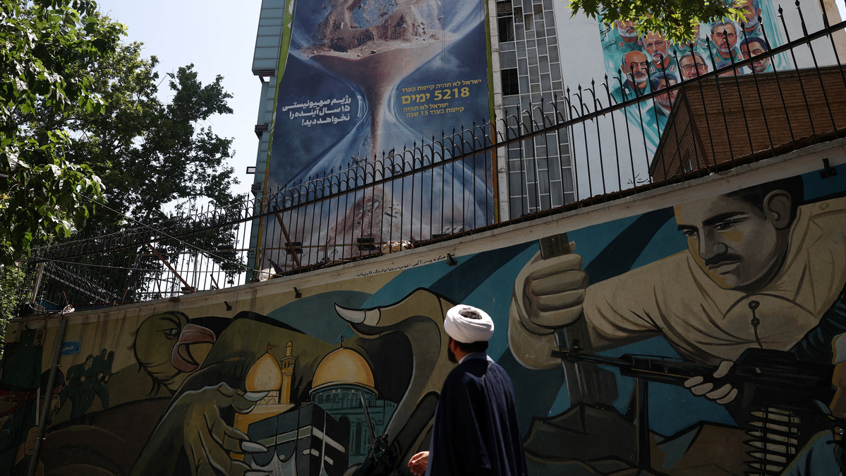 An Iranian cleric walks next to an anti-Israeli billboard on a building in Tehran, Iran, June 9, 2026. Majid Asgaripour/WANA (West Asia News Agency) via REUTERS