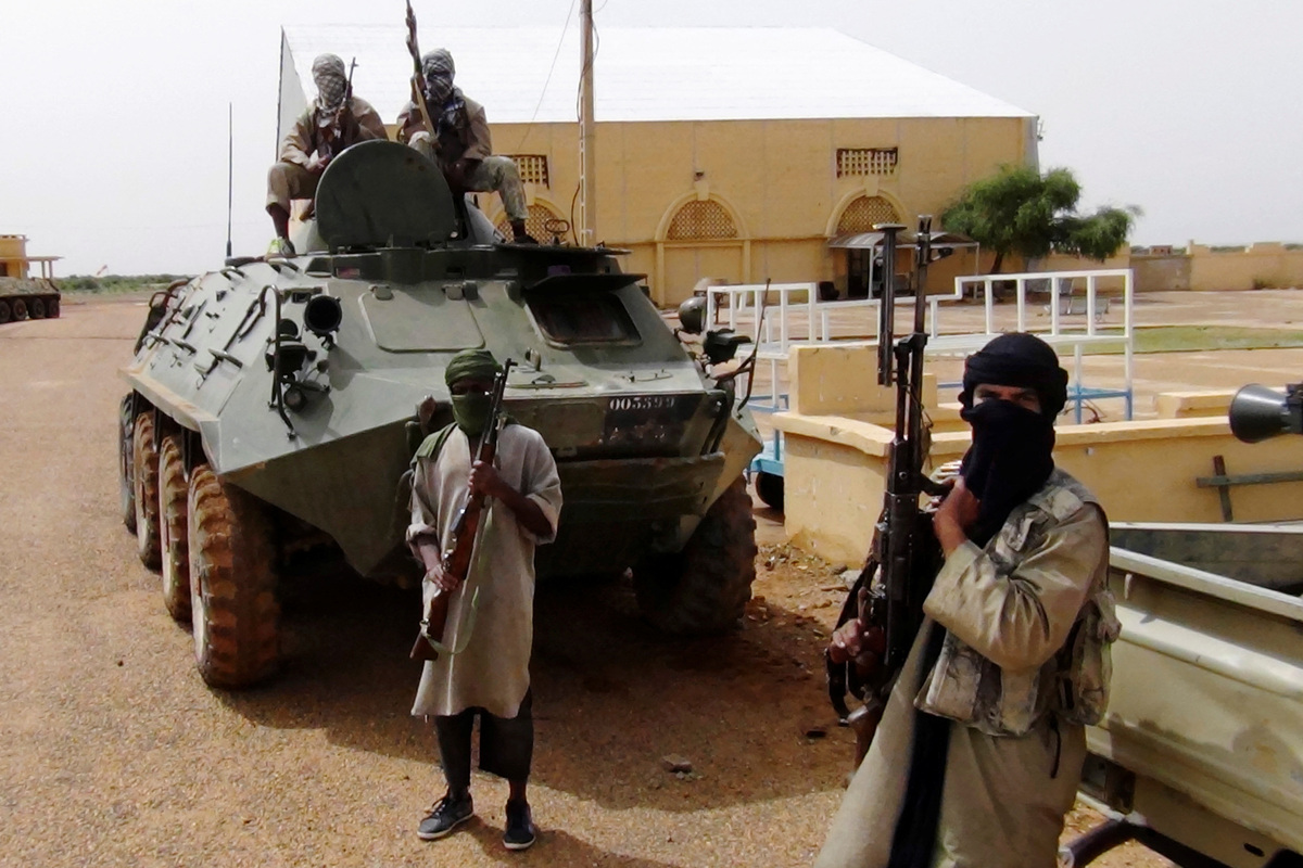 FILE PHOTO: Fighters from the Al Qaeda-linked Islamist group MUJWA, who are travelling with a convoy including Burkina Faso foreign minister Djibril Bassole, stand guard in Gao, northern Mali, August 7, 2012. REUTERS/Stringer/File Photo