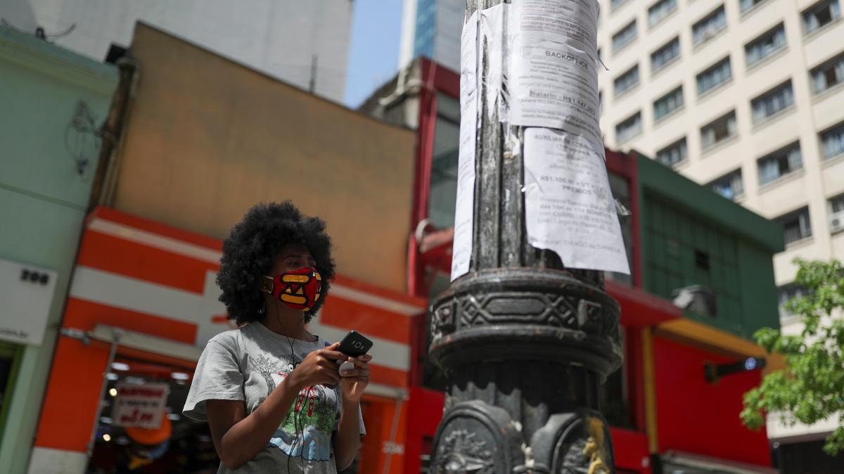 A woman looks at job listings posted on a light pole in downtown Sao Paulo, Brazil, September 30, 2020. REUTERS/Amanda Perobelli