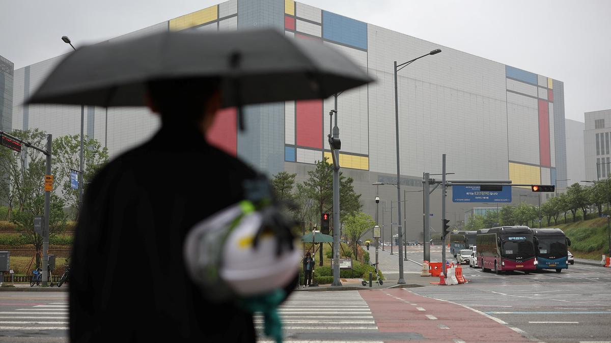 An employee waits to cross a zebra crossing as he heads to work at Samsung Electronics semiconductor plant in Pyeongtaek, South Korea, May 21, 2026.   REUTERS/Kim Hong-Ji