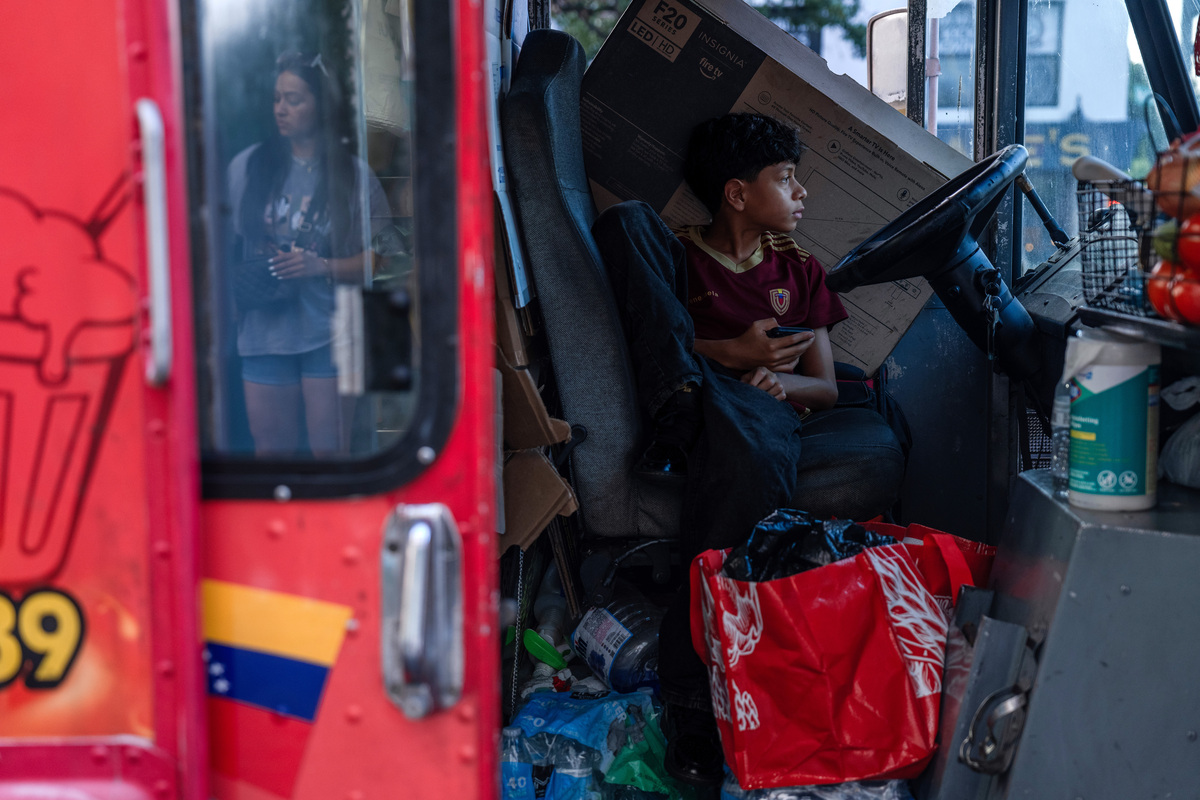 A child sits in ChamolandiaNY, a food truck that sells Venezuelan-style hot dogs, in the Jackson Heights neighborhood of Queens, on Thursday, June 25, 2026. ChamolandiaNY is soliciting relief donations that will be turned over to a foundation for shipment to Venezuela, said the owner, Helmer Gelves, after two earthquakes struck on Wednesday. (Lexi Parra/The New York Times)