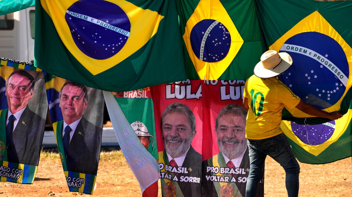 ARCHIVO - Retratos del presidente Jair Bolsonaro, a la izquierda, y del exmandatario Luiz Inácio Lula da Silva, al centro, cuelgan en el exterior de al Corte Suprema Electoral en Brasilia, abajo de banderas brasileñas, el 5 de septiembre de 2022. Bolsonaro y Lula da Silva se disputan la presidencia de Brasil.