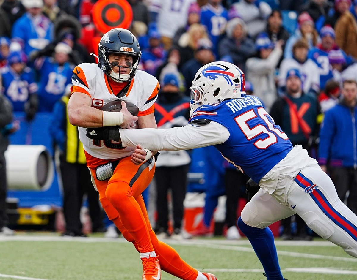  Broncos quarterback Bo Nix gets grabbed by and then sacked by Bills defensive end Greg Rousseau.