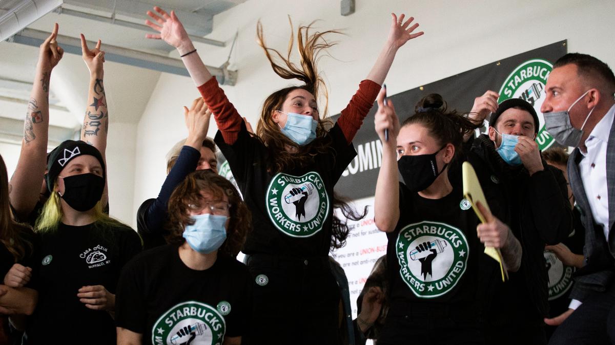 Empleados y simpatizantes de Starbucks reaccionan mientras se leen los votos durante su elección sindical, el jueves 9 de diciembre de 2021, en Buffalo, Nueva York. Los trabajadores de Starbucks votaron a favor de la sindicalización a pesar de las objeciones de la empresa, señalando el camino hacia un nuevo modelo laboral para el gigante del café de 50 años. (AP Photo/Joshua Bessex)